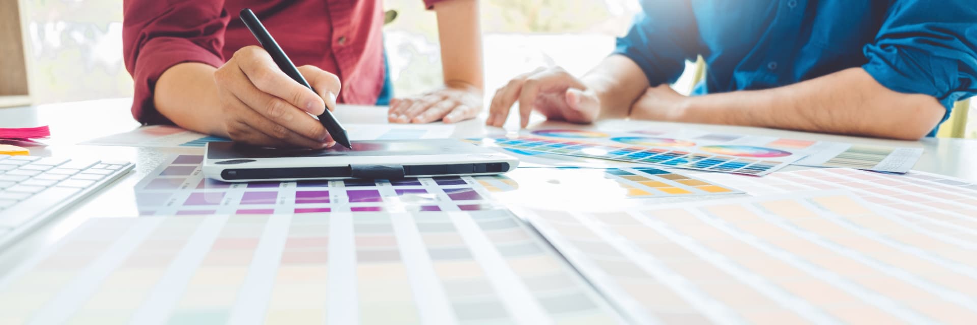 Designers reviewing color palettes and brand swatches on a bright studio table
